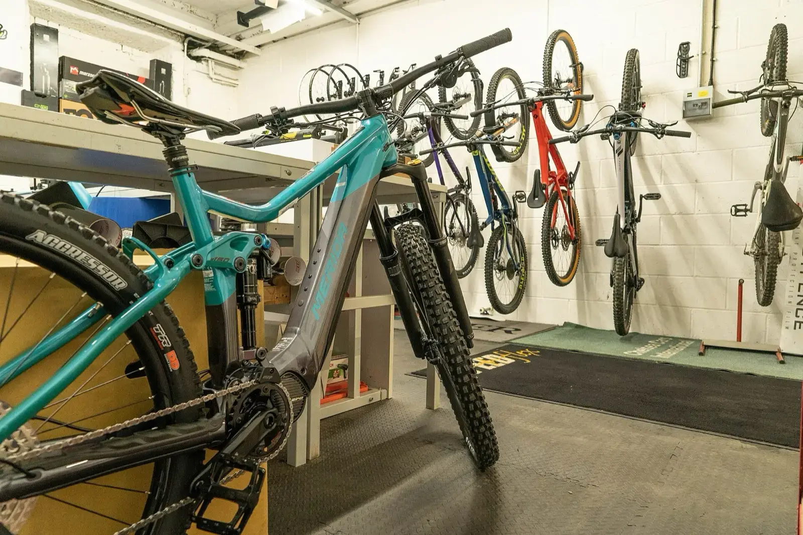 Officina con una mountain bike sul cavalletto di lavoro e altre bici appese alla rastrelliera